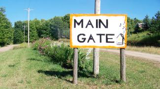 Main gate entrance to Farm Fest, which leads to the front gate. Main gate = front gate. It's the drive on the right, where we will be waiting merrily for you with wristbands and meal passes.
